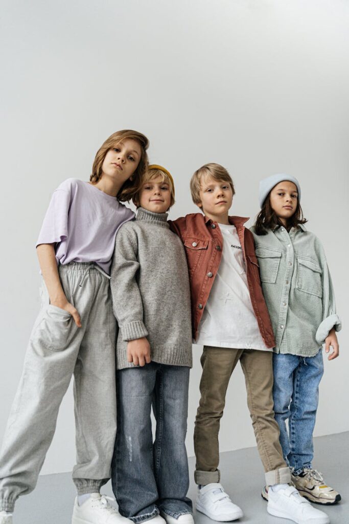 Stylish group of children posing in winter fashion attire indoors.